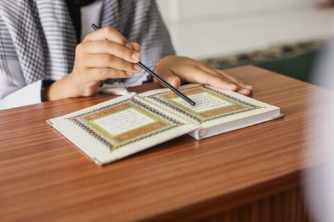 close-up-portrait-muslim-man-hands-pointing-letters-while-reading-quran-with-stick