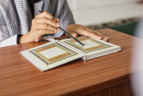 close-up-portrait-muslim-man-hands-pointing-letters-while-reading-quran-with-stick