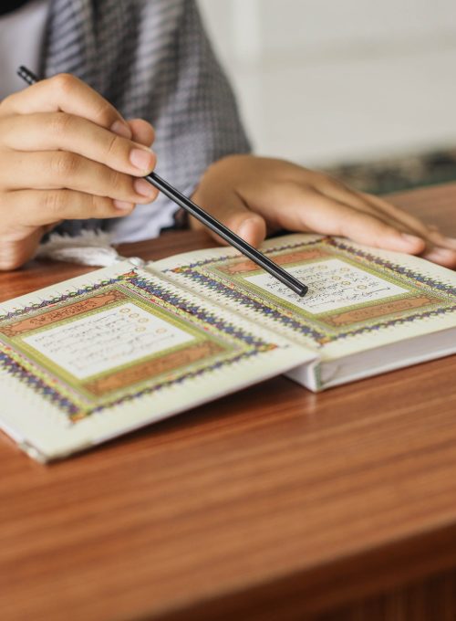 close-up-portrait-muslim-man-hands-pointing-letters-while-reading-quran-with-stick