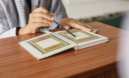 close-up-portrait-muslim-man-hands-pointing-letters-while-reading-quran-with-stick