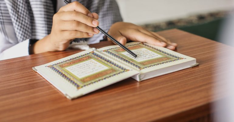 close-up-portrait-muslim-man-hands-pointing-letters-while-reading-quran-with-stick