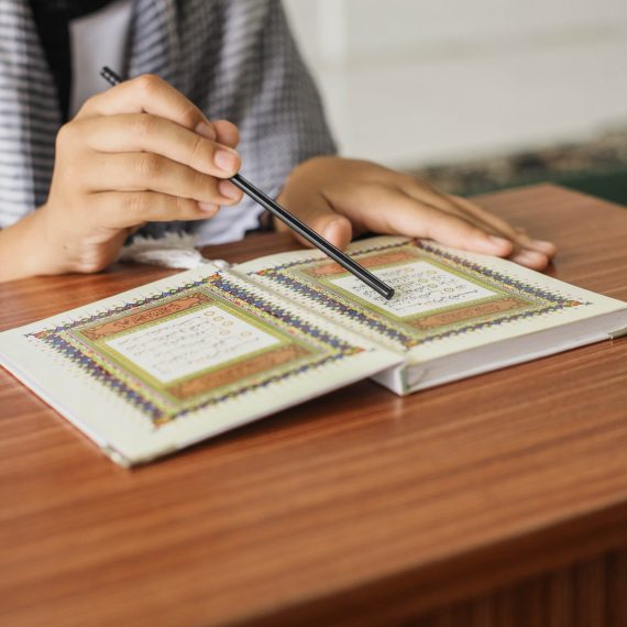close-up-portrait-muslim-man-hands-pointing-letters-while-reading-quran-with-stick